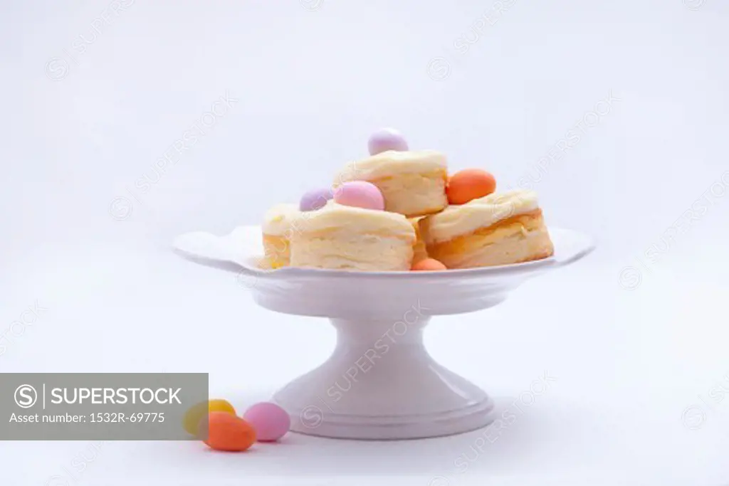 Mini cheesecakes with vanilla custard and marzipan eggs on a cake stand