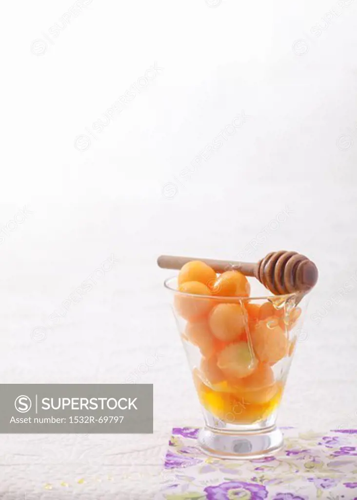 Melon balls with honey in a glass