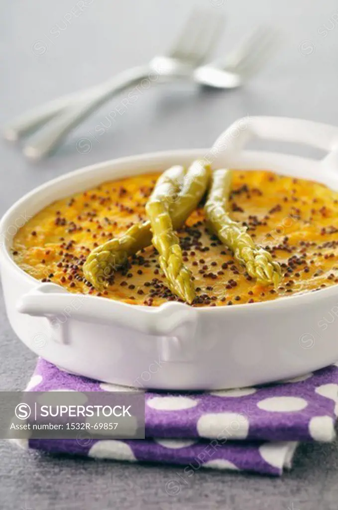 Carrot custard flan with poppy seeds and green asparagus