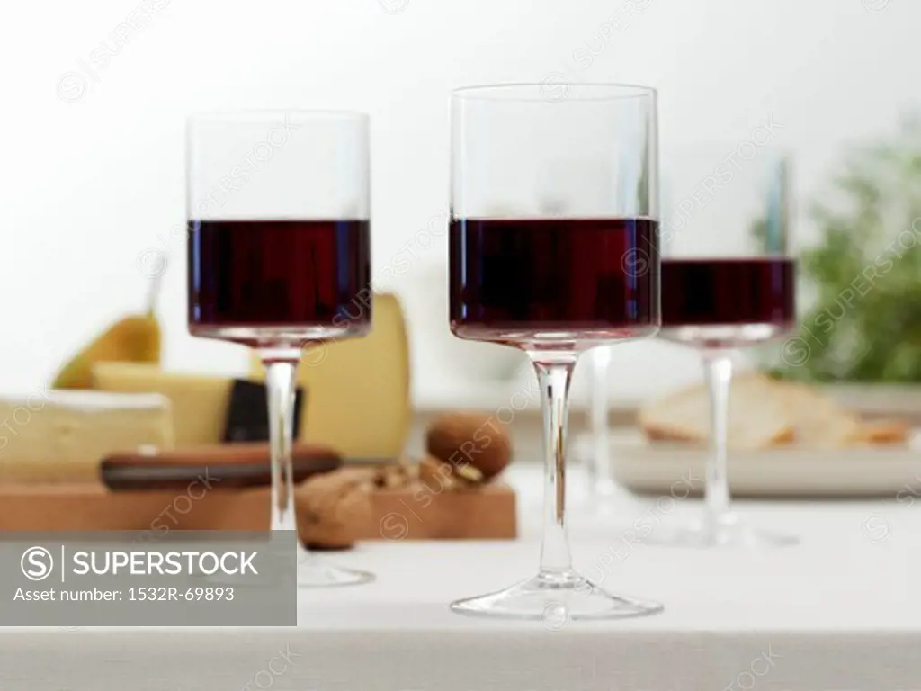 Glasses of red wine in front of a cheeseboard
