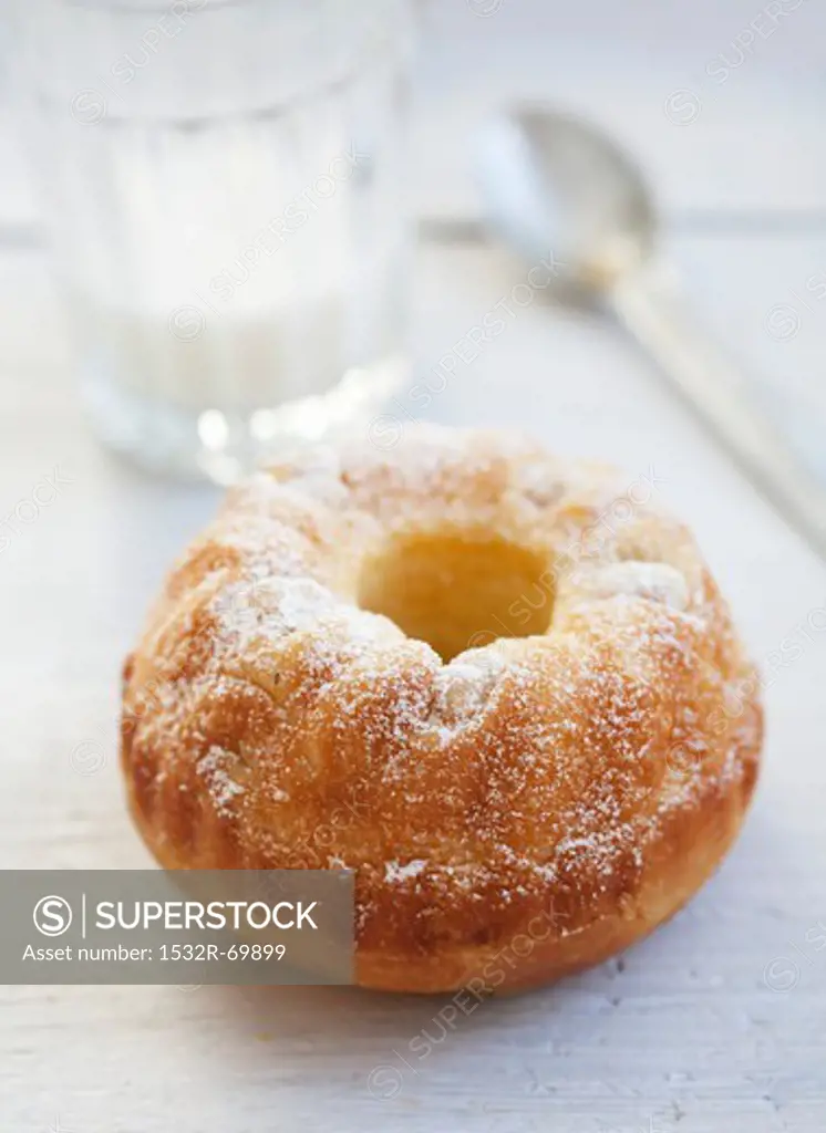 A mini Bundt cake with pieces of pear and icing sugar