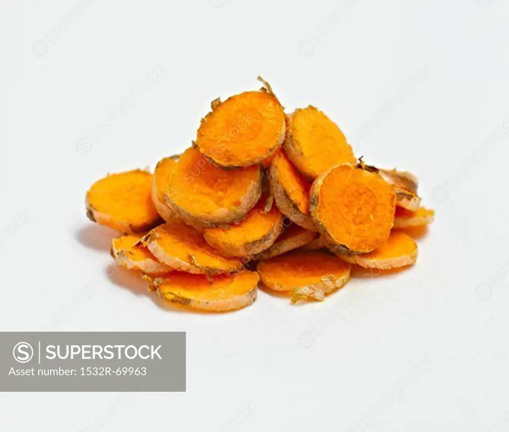 Sliced Turmeric Root Piled on a White Background