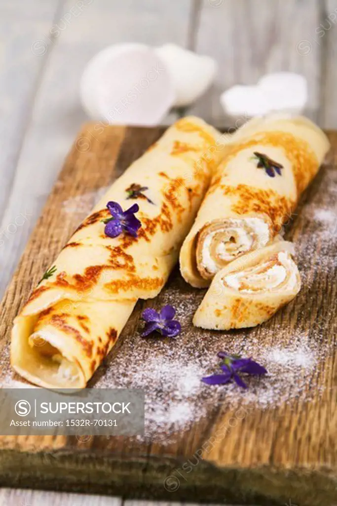 Pancakes filled with cream cheese, with violets