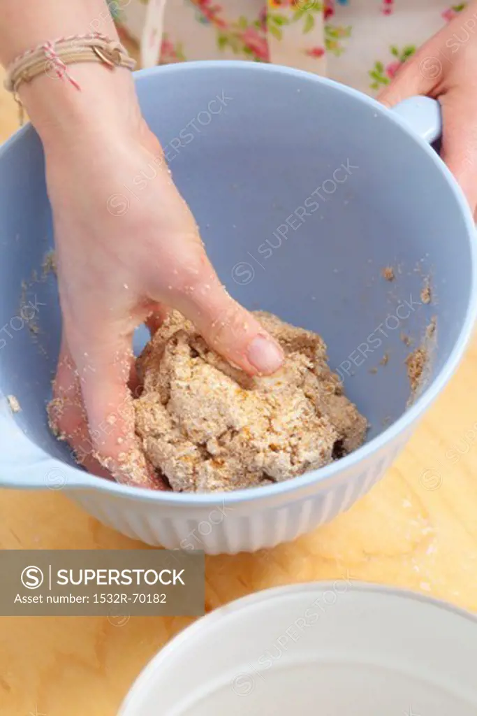 Biscuit dough being kneaded in a bowl