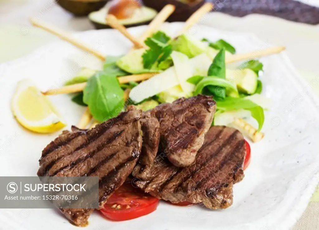 Barbecued beef steaks with avocado salad