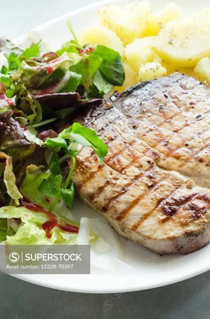 Barbecued tuna steak with potatoes and salad