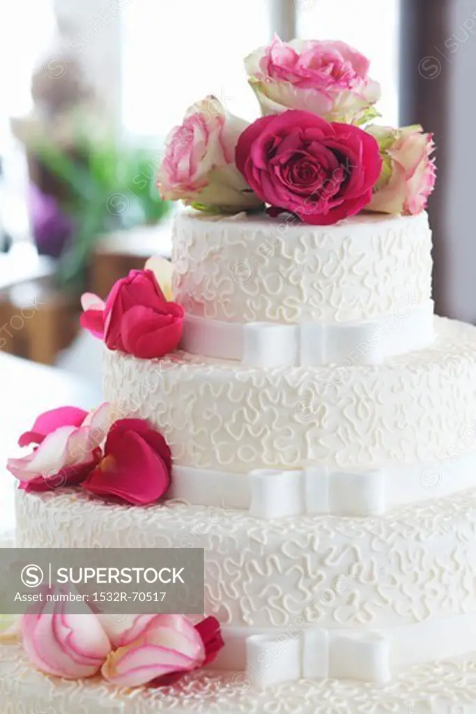 An elegant wedding cake decorated with fresh roses