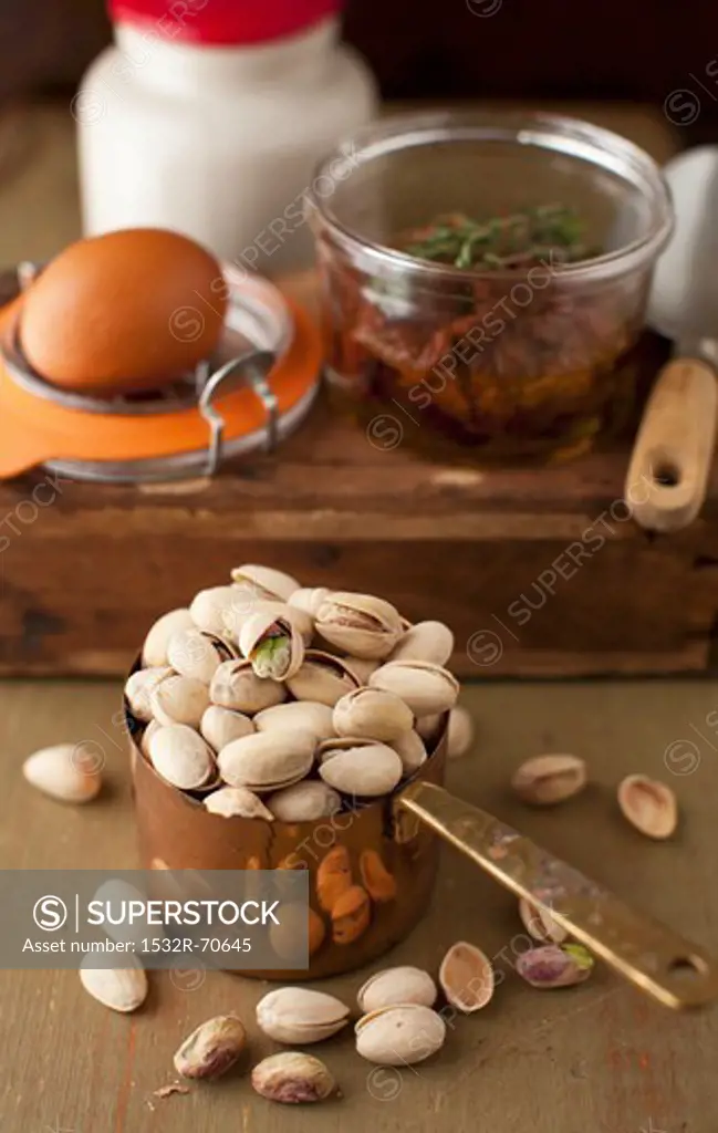Pistachios in a Measuring Cup with Egg and Sun Dried Tomatoes in Background