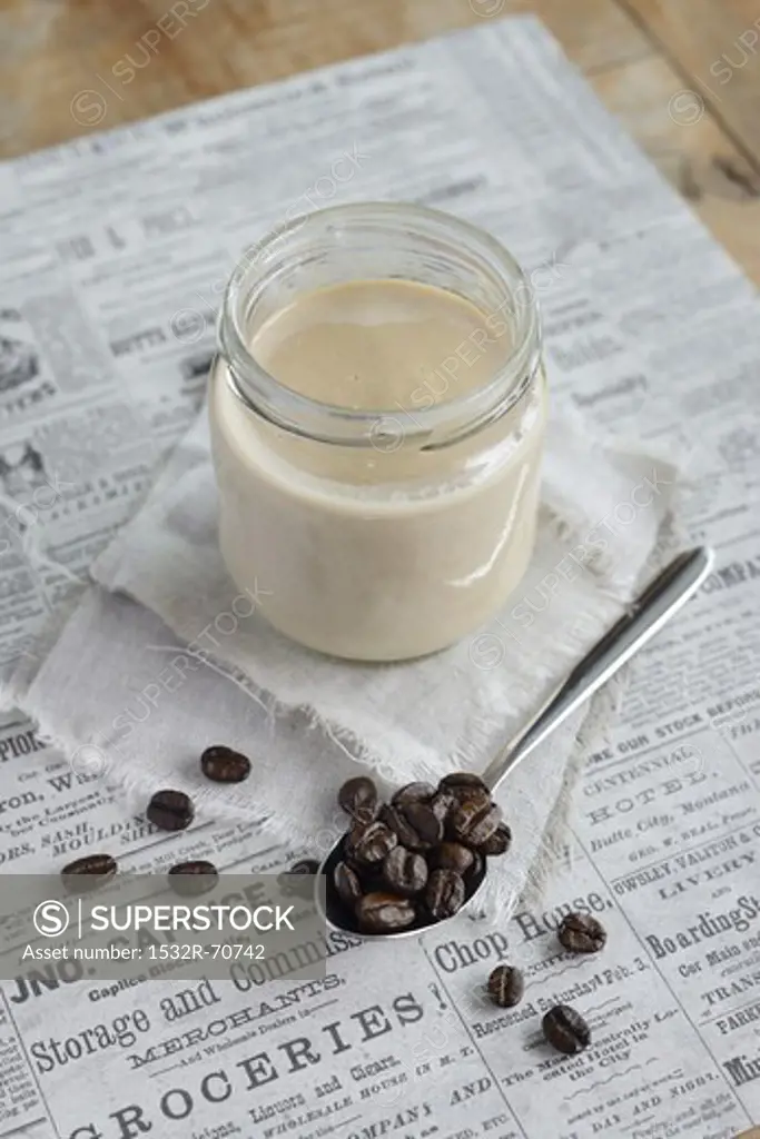 Latte in a screw-top jar, with coffee beans to one side