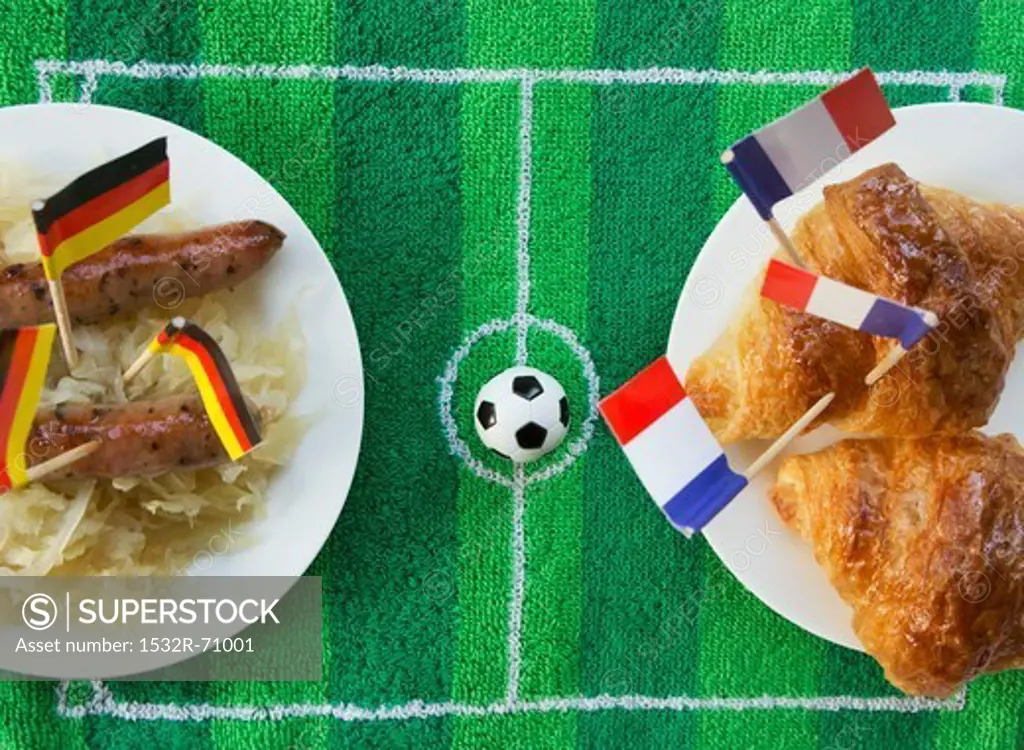 Sausages with cabbage (Germany) and croissants (France) with football-themed decoration