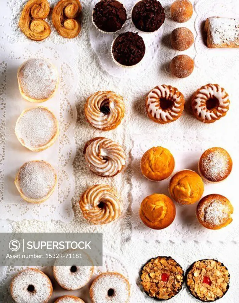 Assorted cakes and pastries on paper doilies