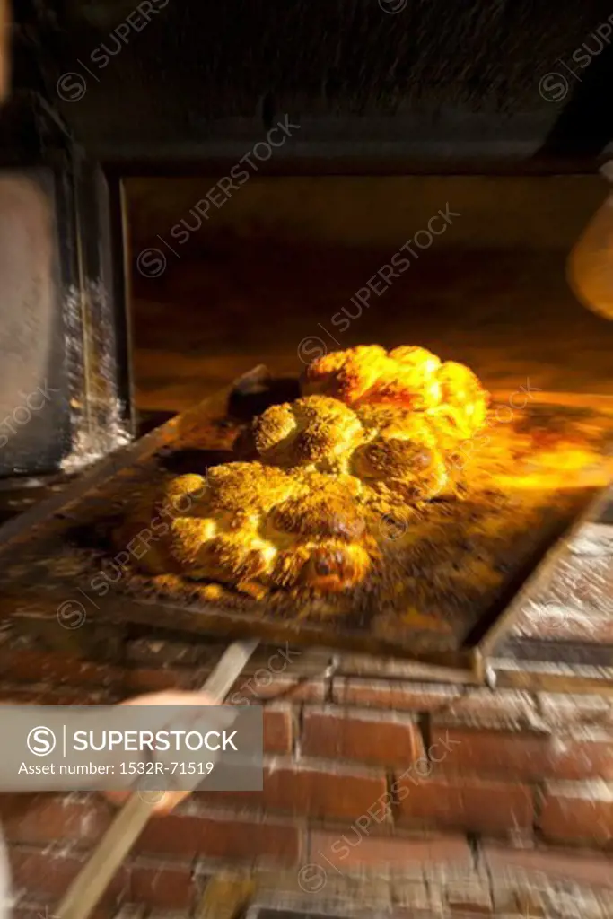 Freshly baked bread rolls on a baking tray in a wood-fired oven