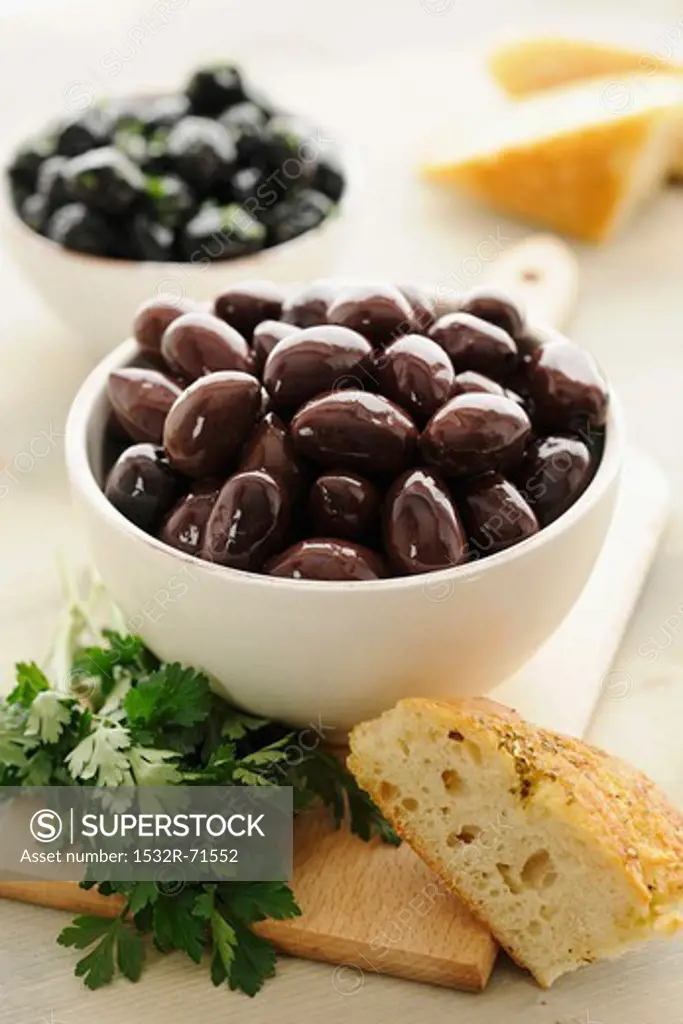 Kalamata olives in a bowl, with parsley and bread