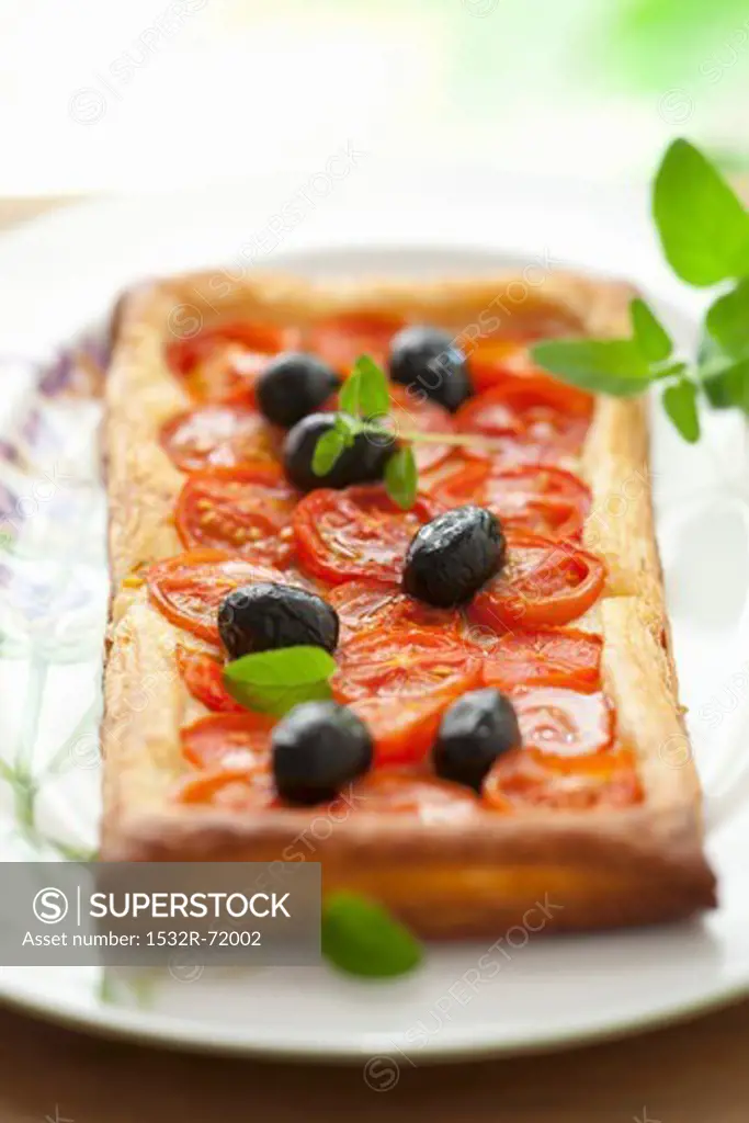 Puff pastry tart with cherry tomatoes, olives and oregano