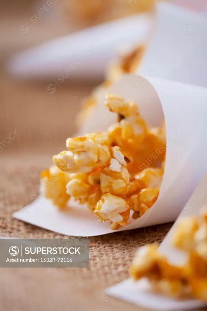 Caramelised popcorn in paper cones (close-up)