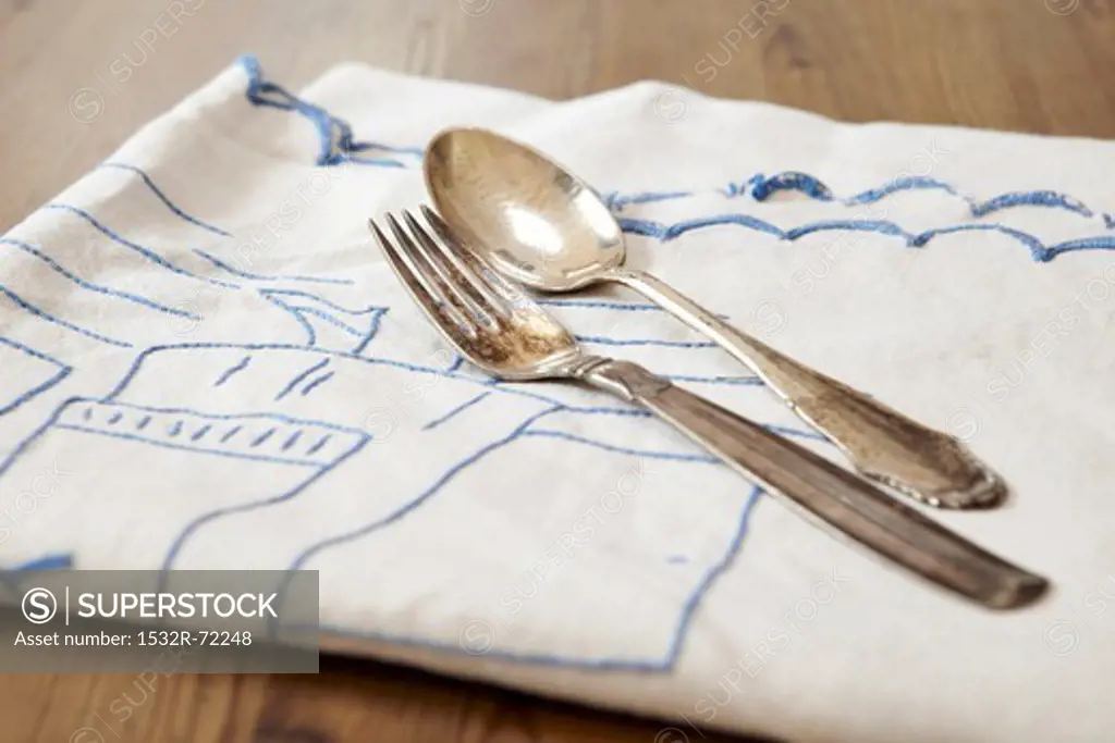A silver fork and a silver spoon on a tea towel