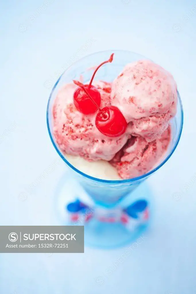 A strawberry and vanilla ice cream sundae with glacé cherries