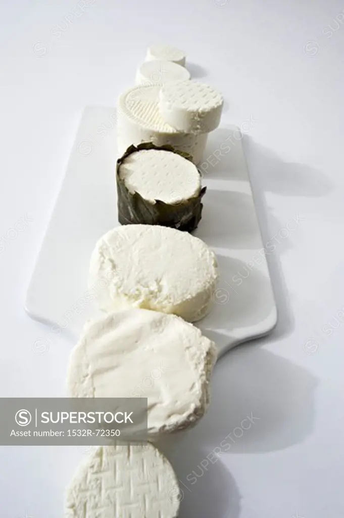 Assorted types of fresh goat's cheese laid out in a row