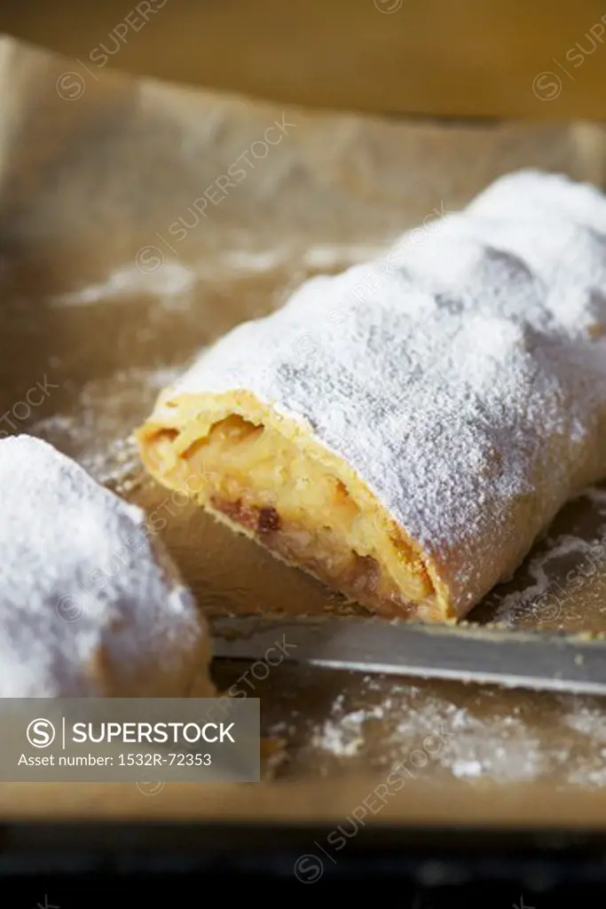 Apple strudel dusted with icing sugar, cut open