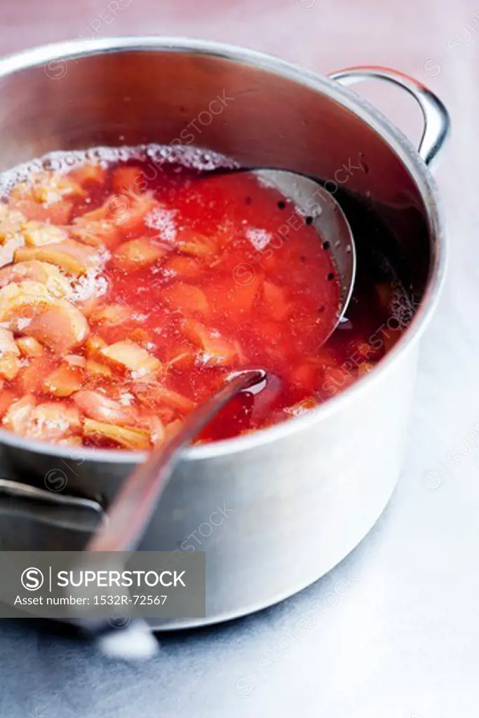 Stewed rhubarb with a skimmer in a saucepan