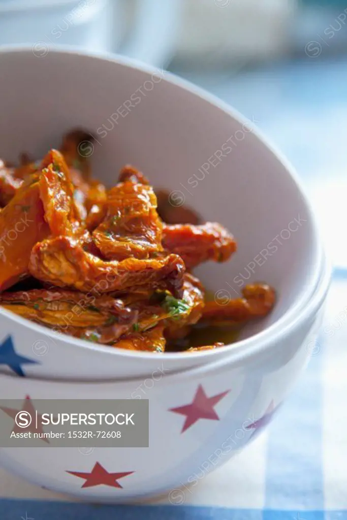 Sundried tomatoes with olive oil and herbs in a bowl