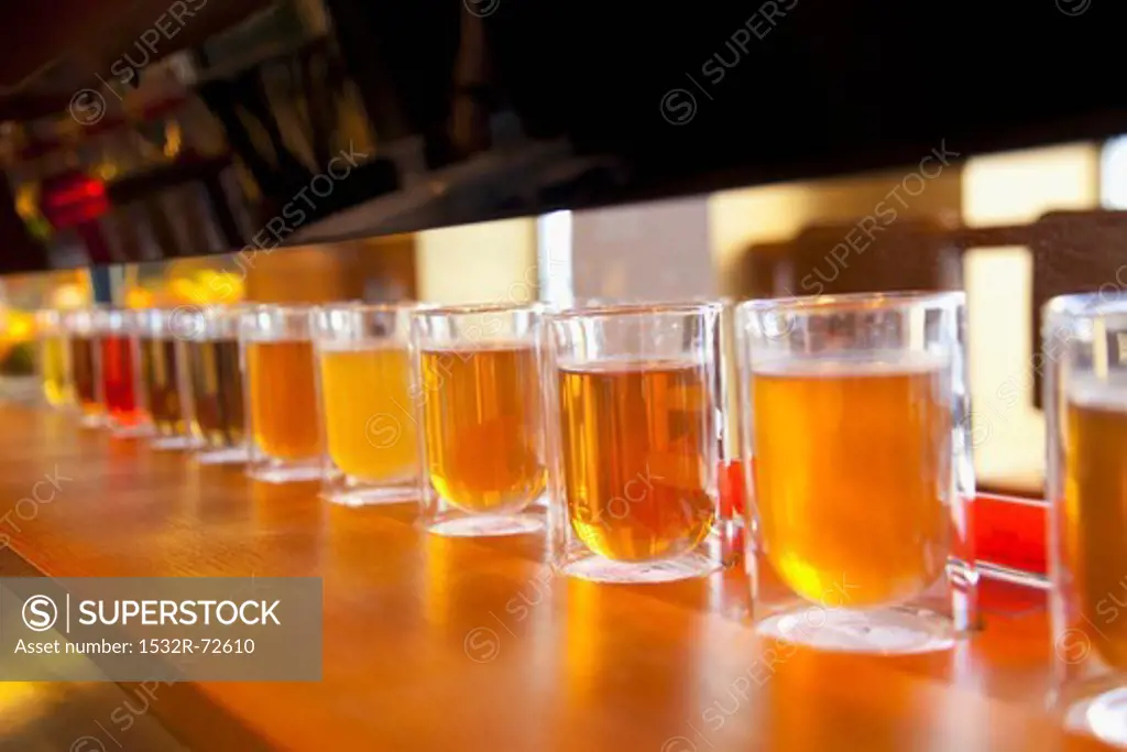 Lots of glasses of different teas in a row