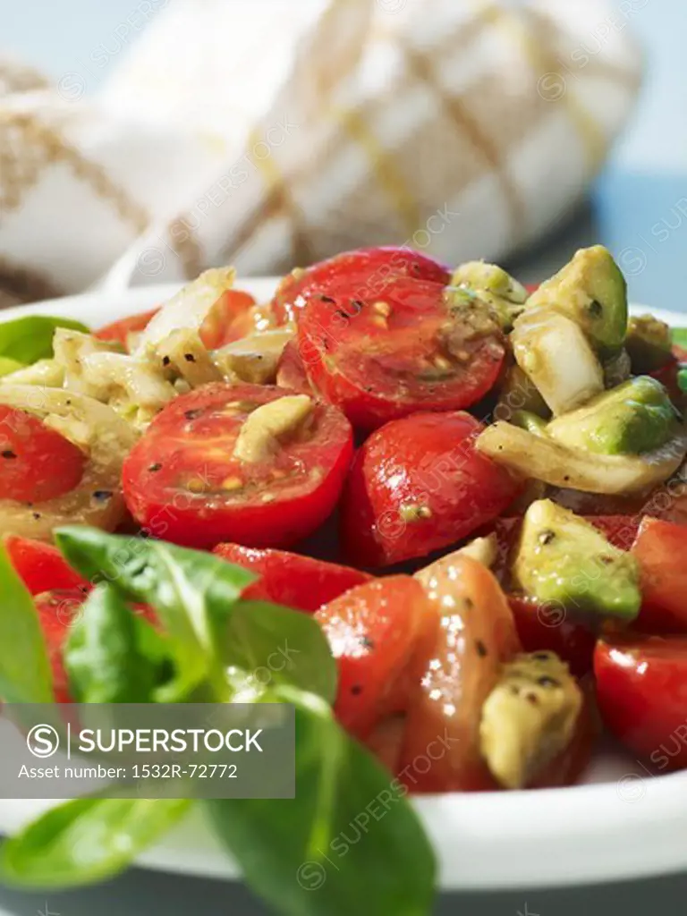 Tomato and avocado salad with onions and olive oil