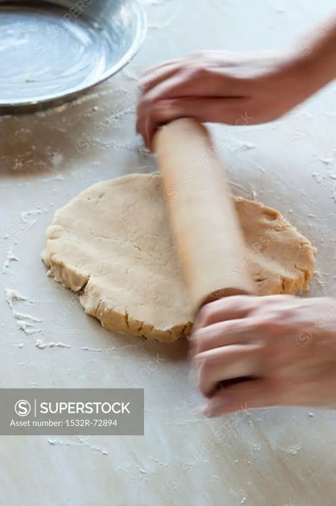 Shortcrust pastry being rolled out with a rolling pin