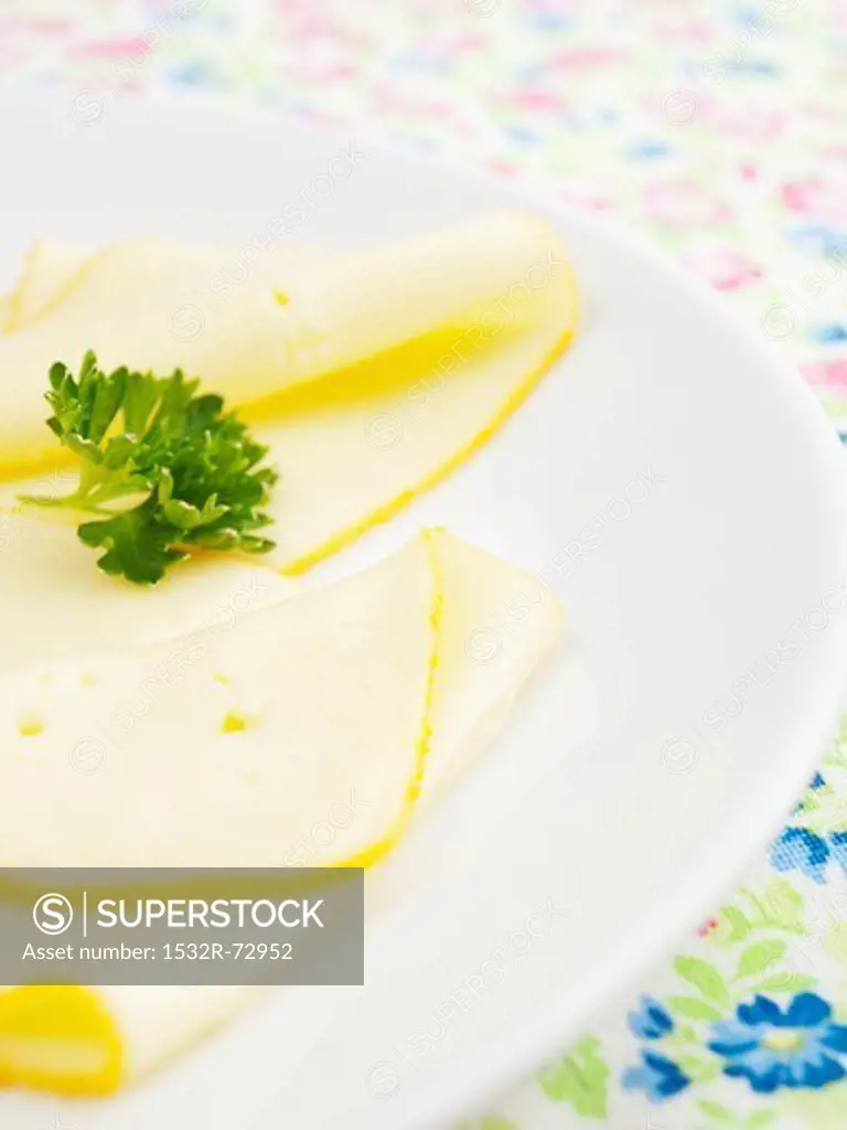 Butterkäse (mild, full fat cheese) in slices on a plate (cut out)