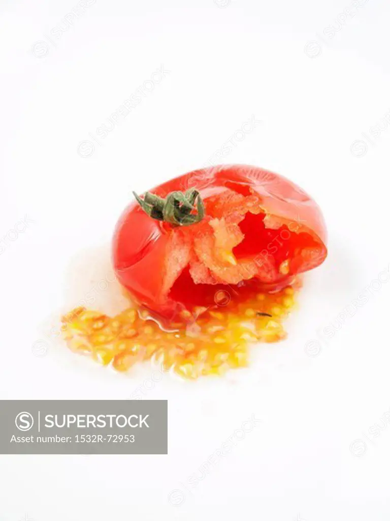 A squeezed tomato against a white background