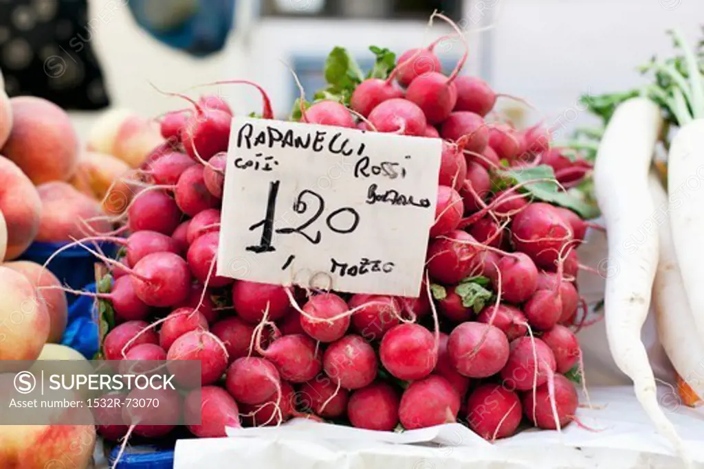 A pile of radishes at the market with a price sign, 7/6/2013