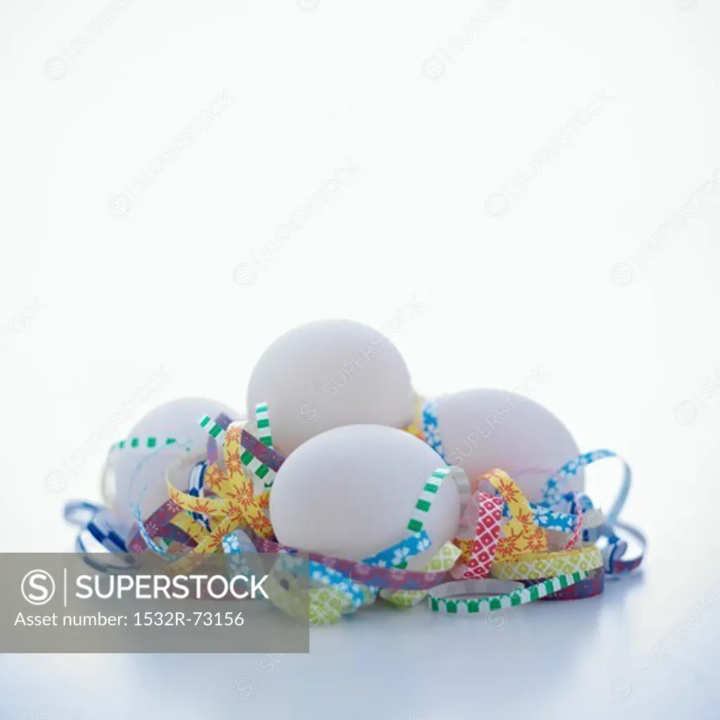 Group of white eggs with curls of shredded paper on a white background, 8/2/2013