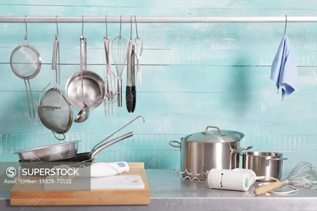 Assorted kitchen utensils on a stainless steel unit and hanging on a metal rod, 8/21/2013