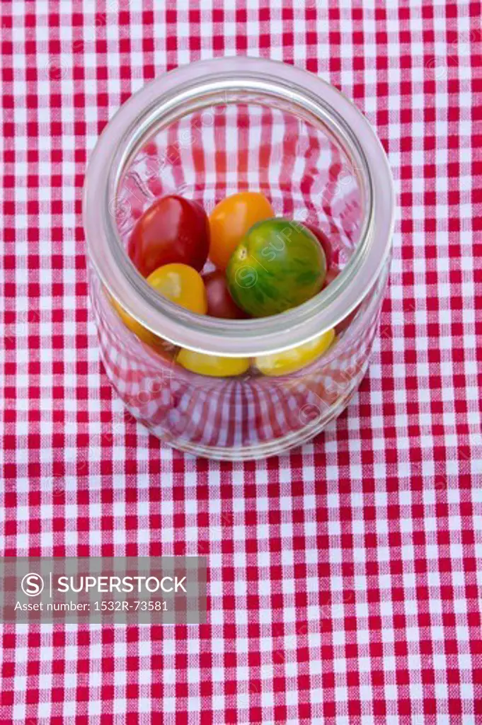 Fresh heirloom tomatoes in a preserving jar on a checked tablecloth, 8/22/2013