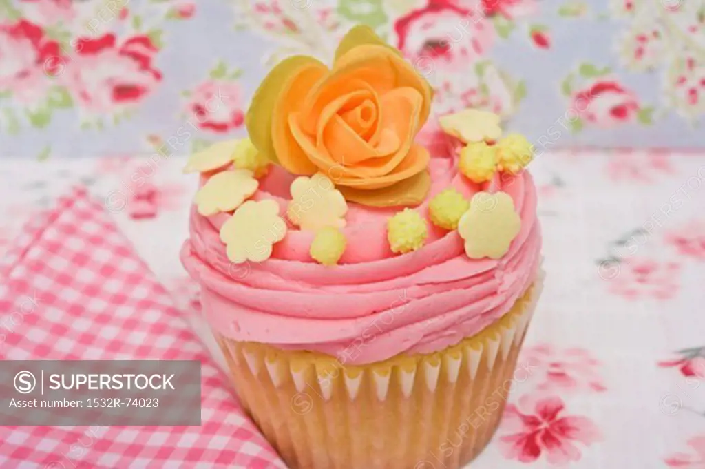 A pink cupcake decorated with a sugar rose and sweets, 9/5/2013
