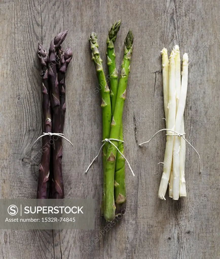 Purple, green and white asparagus stalks on a wooden surface, 9/18/2013
