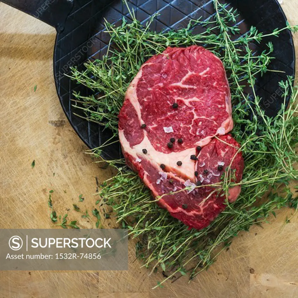 Rib eye steak with thyme on a black frying pan, 9/18/2013