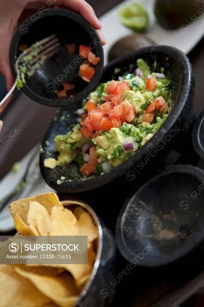 Woman Making Guacamole on Lap with Mortar and Pestle, 10/19/2013