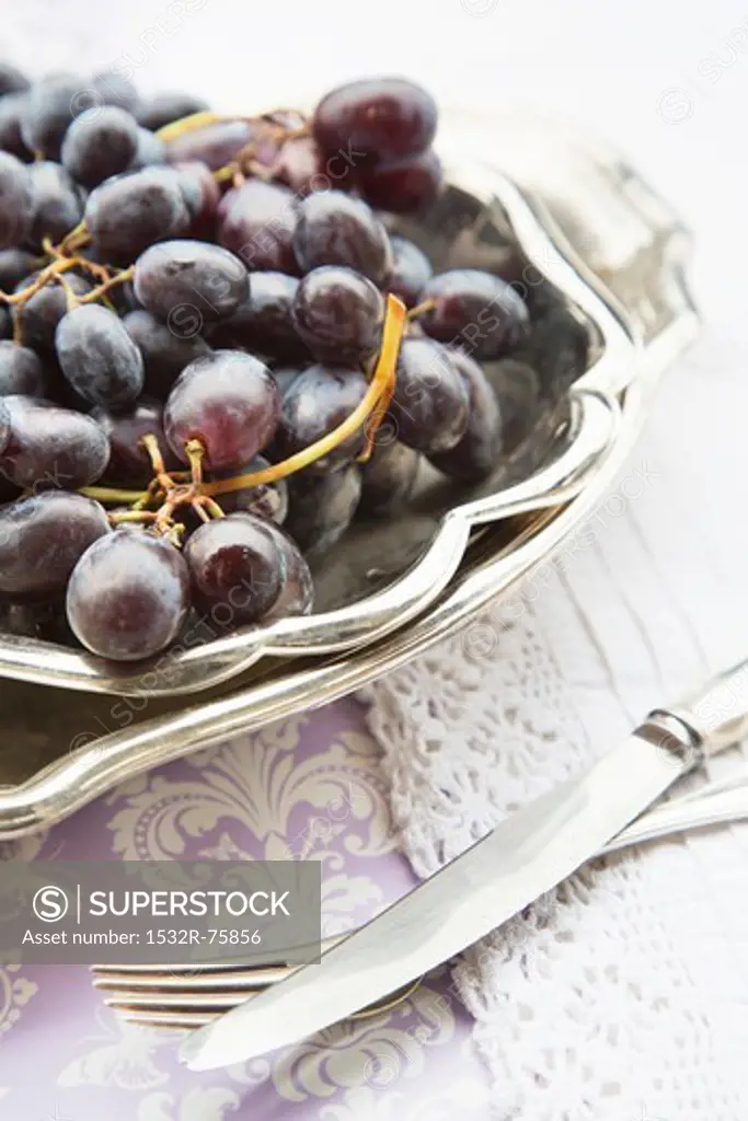 Red grapes in a silver dish with silver cutler to one side, 10/22/2013