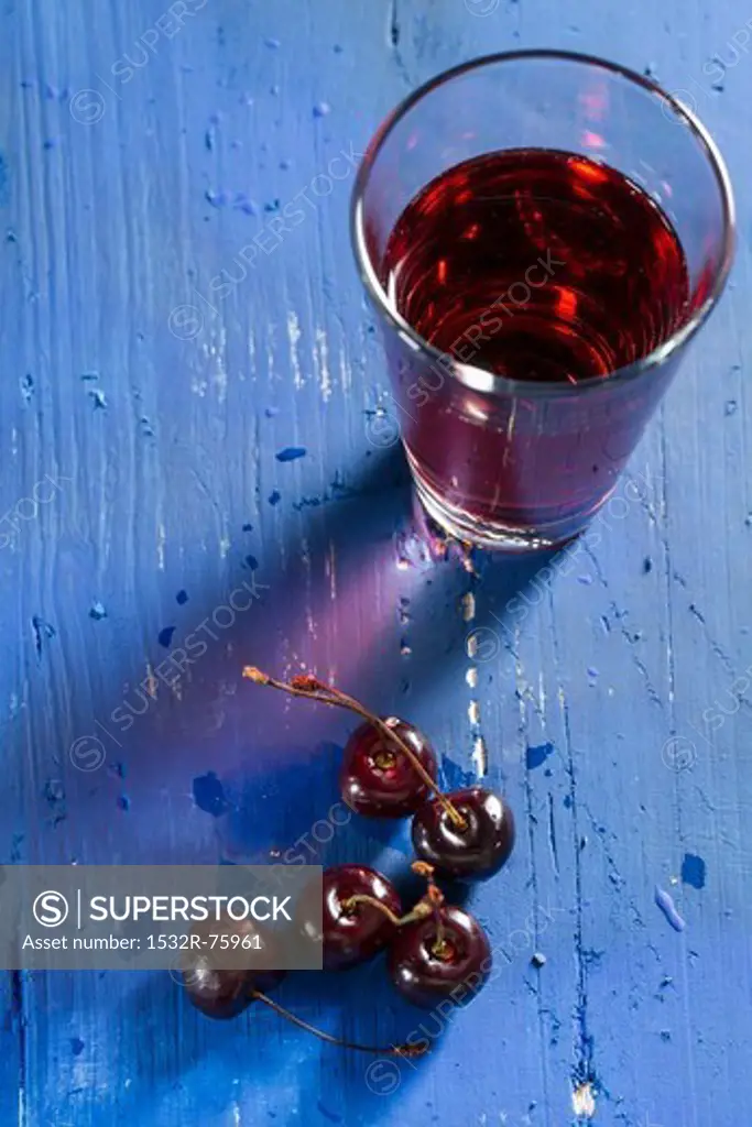 Cherries and cherry juice on a blue wooden tabletop, 10/23/2013