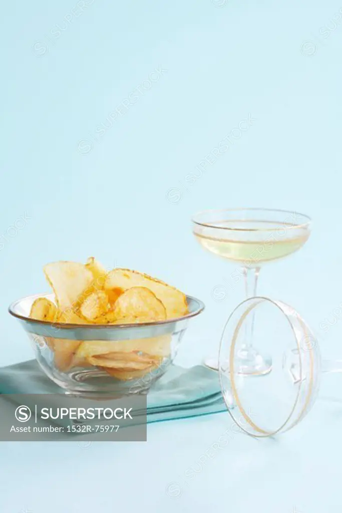 Potato crisps in a glass bowl served with a glass of champagne, 11/9/2013