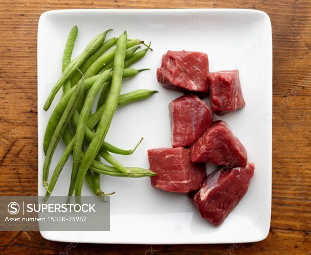 Raw Chunks of Beef and String Beans on a White Plate from Overhead, 11/7/2013