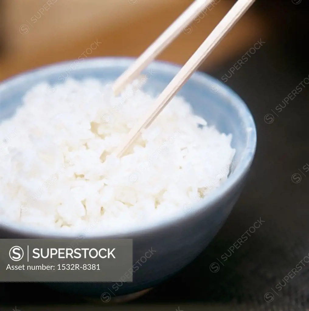 A Bowl of Cooked White Rice with Chopsticks