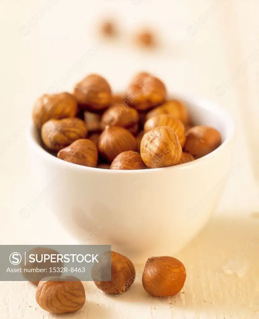Hazelnut kernels in small white bowl