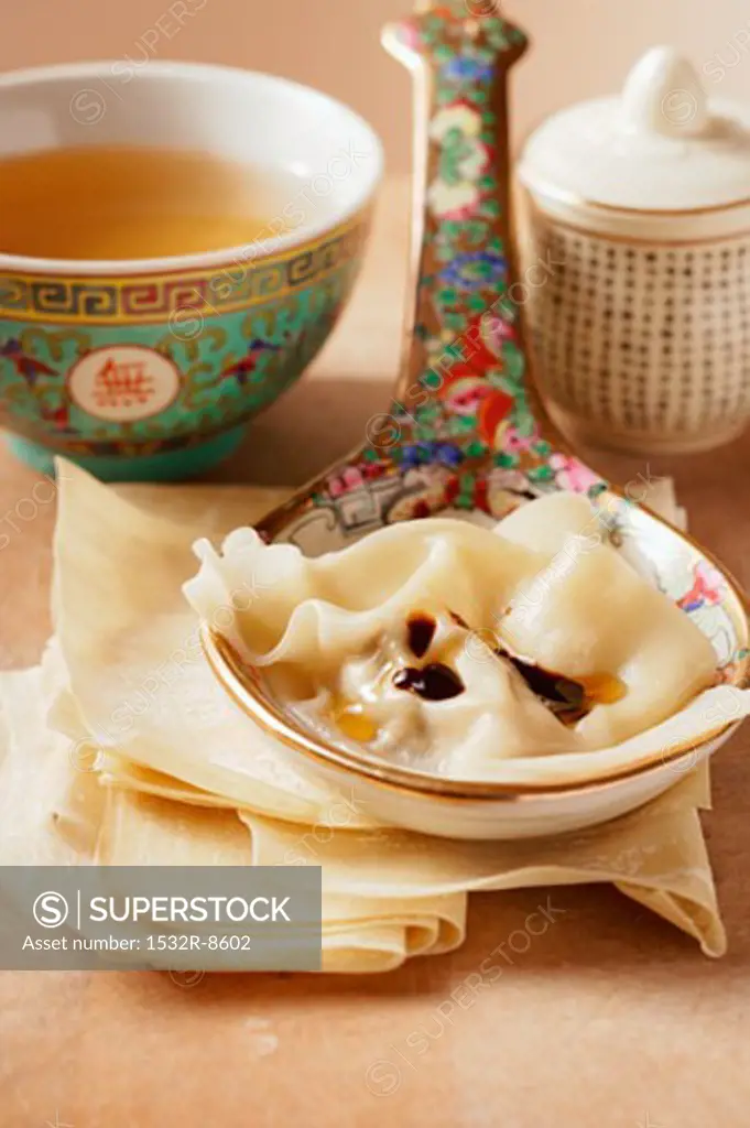 Won tons on spoon; clear broth in small bowl