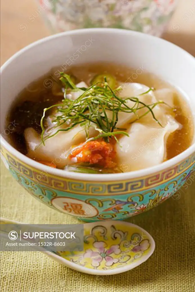 Broth with won tons, chili sauce & strips of lemon leaves