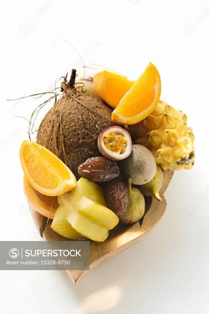 Exotic fruit still life with coconut in wooden bowl