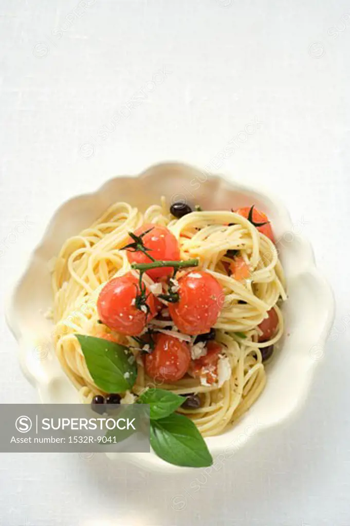 Spaghetti with cherry tomatoes, olives, cheese and basil