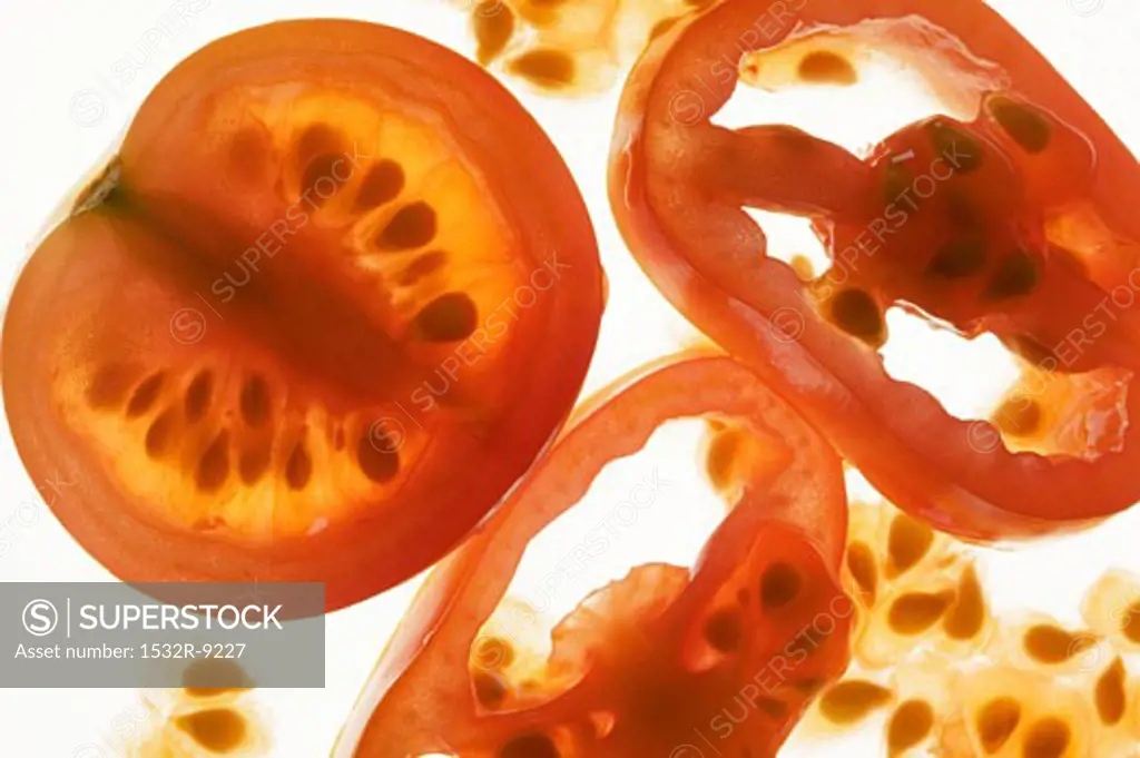 Tomato half and tomato slices, backlit
