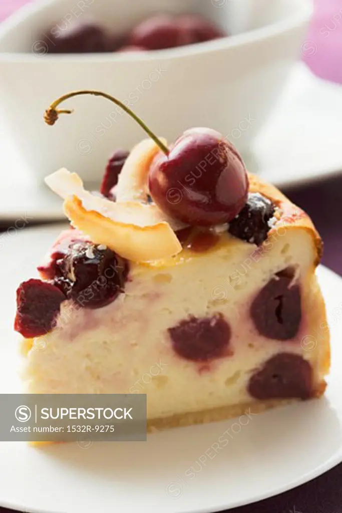 Piece of cheesecake with cherries and coconut shavings